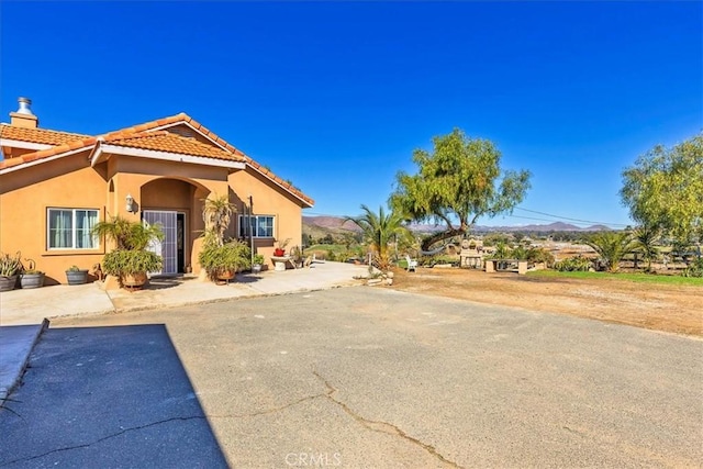 view of front of property featuring stucco siding and a tiled roof