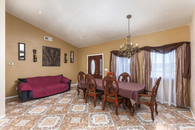 dining room featuring lofted ceiling, baseboards, visible vents, and a chandelier