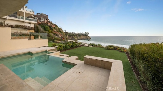 pool with a beach view, a yard, a patio area, and a water view