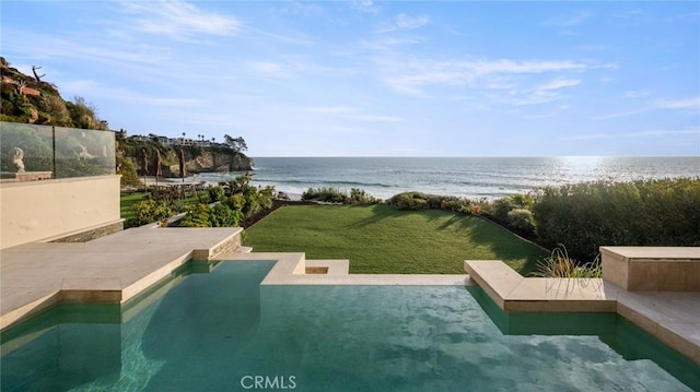 view of swimming pool featuring a water view, a lawn, a patio, and an infinity pool