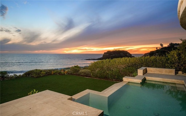 view of swimming pool with a yard, a patio, and a water view