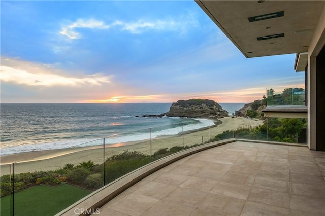 balcony featuring a beach view and a water view