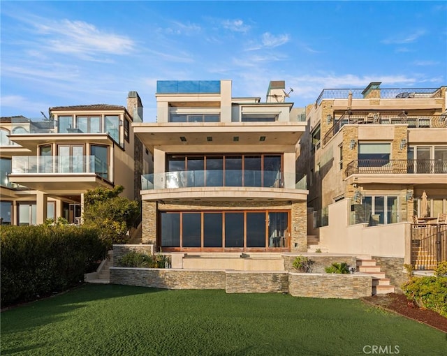 rear view of property with a yard and stucco siding