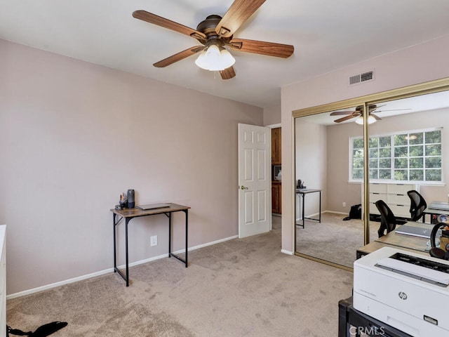 office with visible vents, light carpet, baseboards, and a ceiling fan