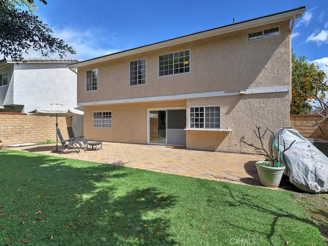 back of property with stucco siding, a patio, and fence