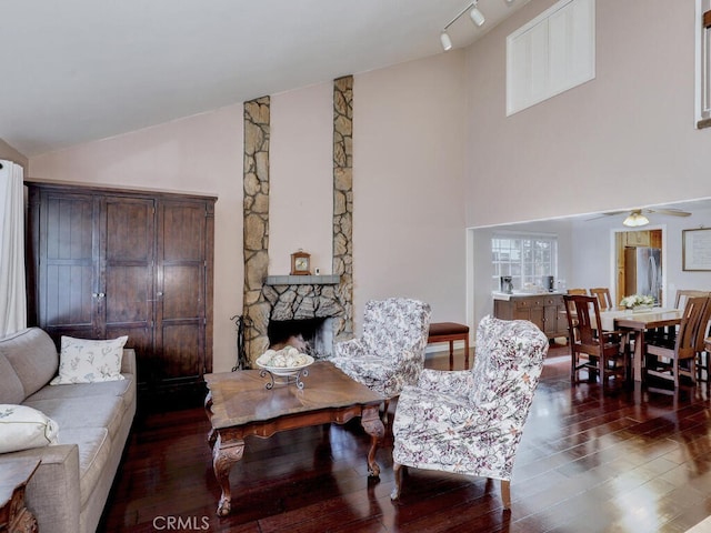 living area featuring wood finished floors, a fireplace, lofted ceiling, and ceiling fan