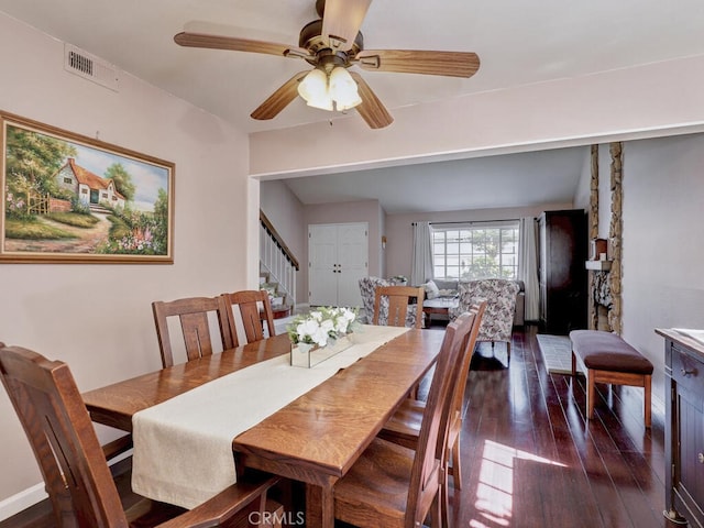 dining area featuring visible vents, stairs, ceiling fan, and dark wood-style flooring