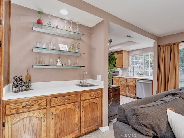 bar with a sink, indoor wet bar, dishwasher, and light tile patterned flooring