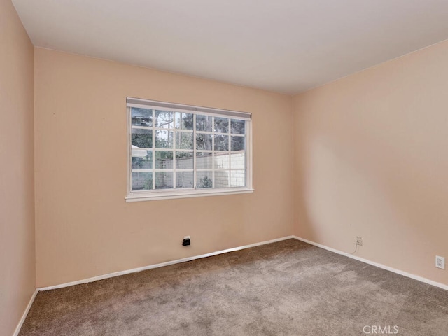 carpeted spare room featuring baseboards