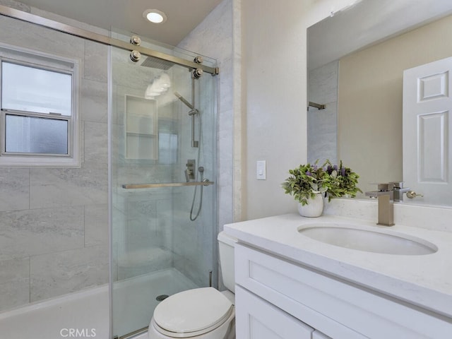 bathroom featuring vanity, toilet, and a shower stall