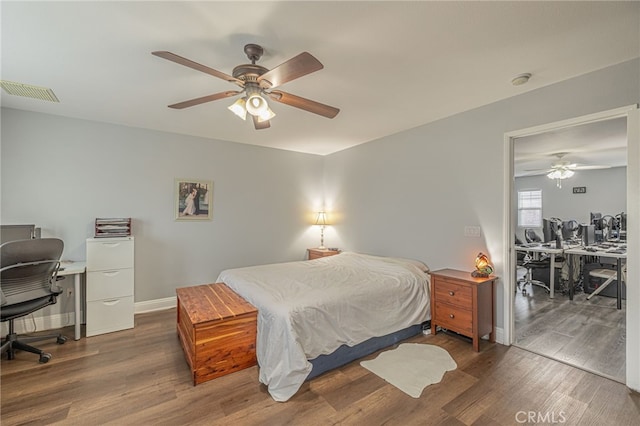 bedroom featuring visible vents, baseboards, wood finished floors, and a ceiling fan