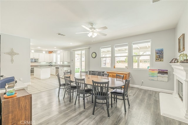 dining room featuring visible vents, plenty of natural light, light wood-style floors, and a ceiling fan