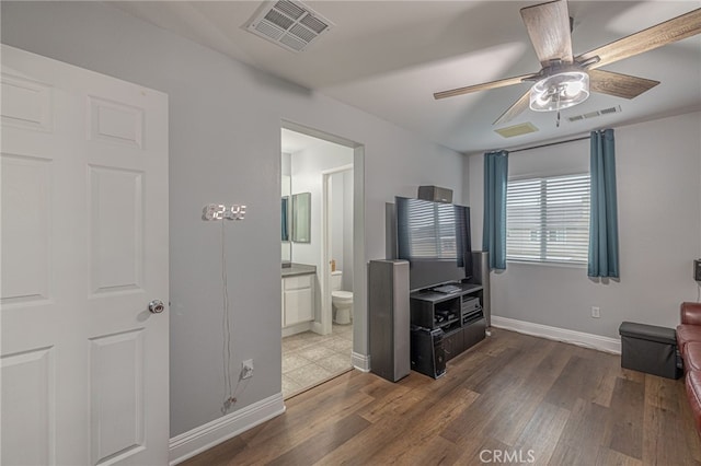 living area with ceiling fan, visible vents, and wood finished floors