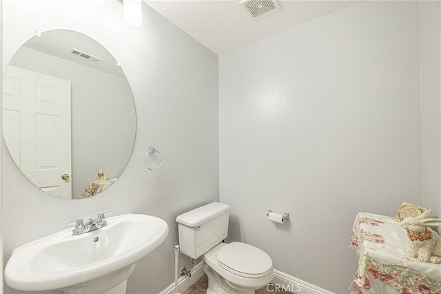 bathroom featuring a sink, visible vents, baseboards, and toilet