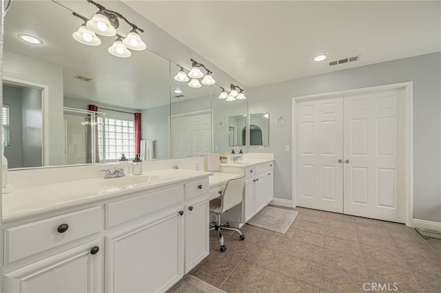 full bath with a sink, visible vents, baseboards, and two vanities