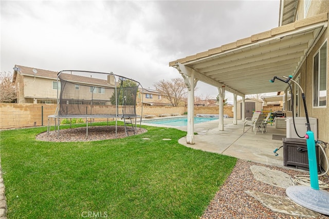 view of yard featuring a patio, a fenced backyard, an outdoor structure, a storage shed, and a trampoline