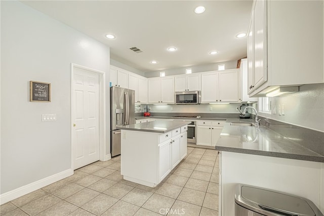 kitchen featuring a sink, white cabinets, a center island, and stainless steel appliances