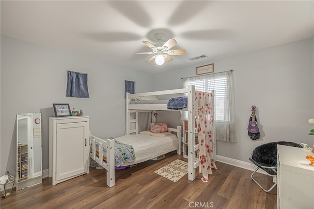 bedroom with visible vents, a ceiling fan, baseboards, and wood finished floors