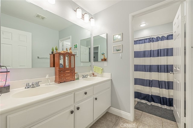 bathroom with a shower with shower curtain, baseboards, double vanity, a sink, and tile patterned flooring