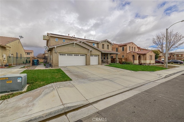 view of front of home featuring stucco siding, fence, concrete driveway, a front yard, and an attached garage