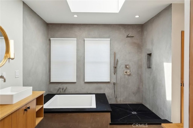 full bathroom with a sink, a garden tub, walk in shower, and double vanity