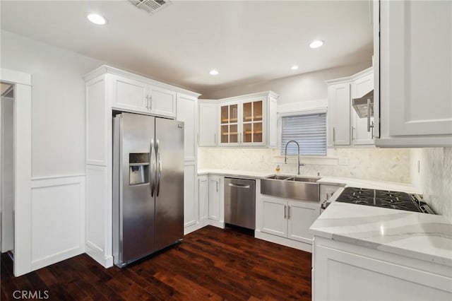 kitchen with a sink, visible vents, white cabinetry, and stainless steel appliances