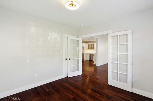 unfurnished room with dark wood finished floors, french doors, and baseboards