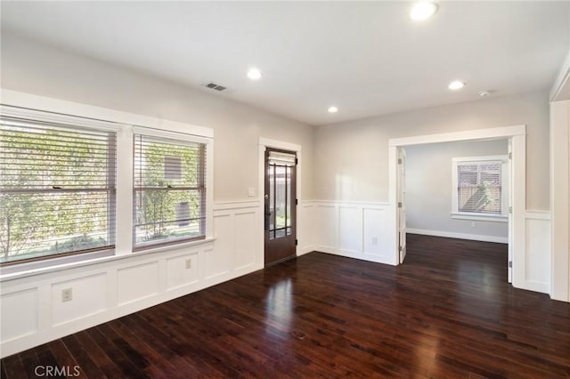 interior space featuring wood finished floors, a wainscoted wall, visible vents, recessed lighting, and a decorative wall