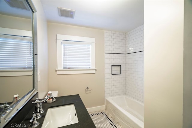 bathroom with visible vents, vanity, bathing tub / shower combination, and baseboards