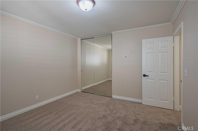 unfurnished bedroom featuring baseboards, a closet, carpet floors, and ornamental molding