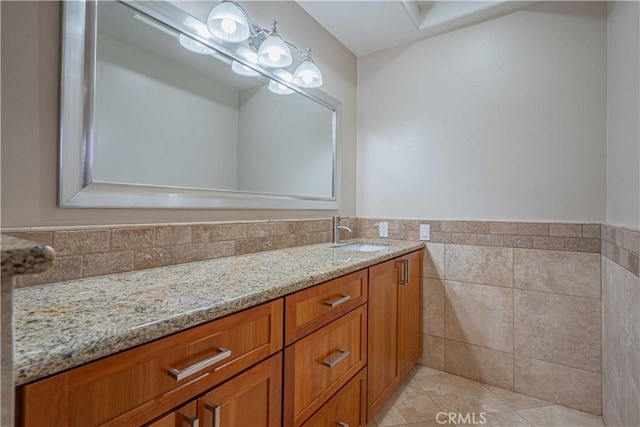 bathroom with tile patterned floors, tile walls, wainscoting, and vanity