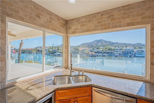 30360 Point Marina Dr, Canyon Lake, CA 92587 - kitchen featuring a sink, brown cabinetry, stone counters, stainless steel dishwasher, and a water view
