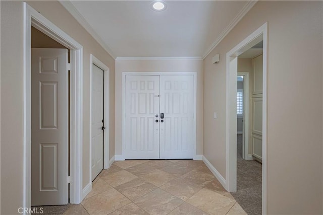 foyer featuring baseboards and crown molding