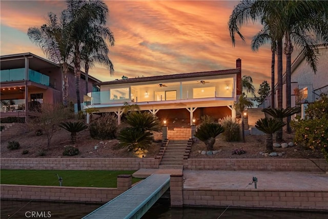 30360 Point Marina Dr, Canyon Lake, CA 92587 - back of house at dusk featuring stairway, a chimney, a balcony, and stucco siding