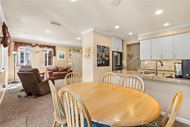 carpeted dining space featuring recessed lighting, baseboards, visible vents, and ornamental molding