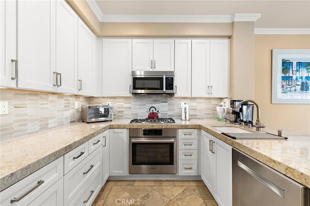 kitchen with a sink, crown molding, white cabinets, and stainless steel appliances