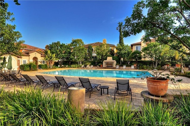 community pool featuring a fireplace and a patio