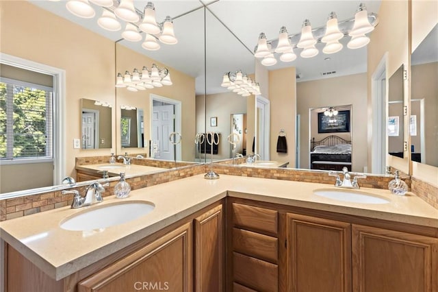 ensuite bathroom with a sink, visible vents, double vanity, and ensuite bathroom