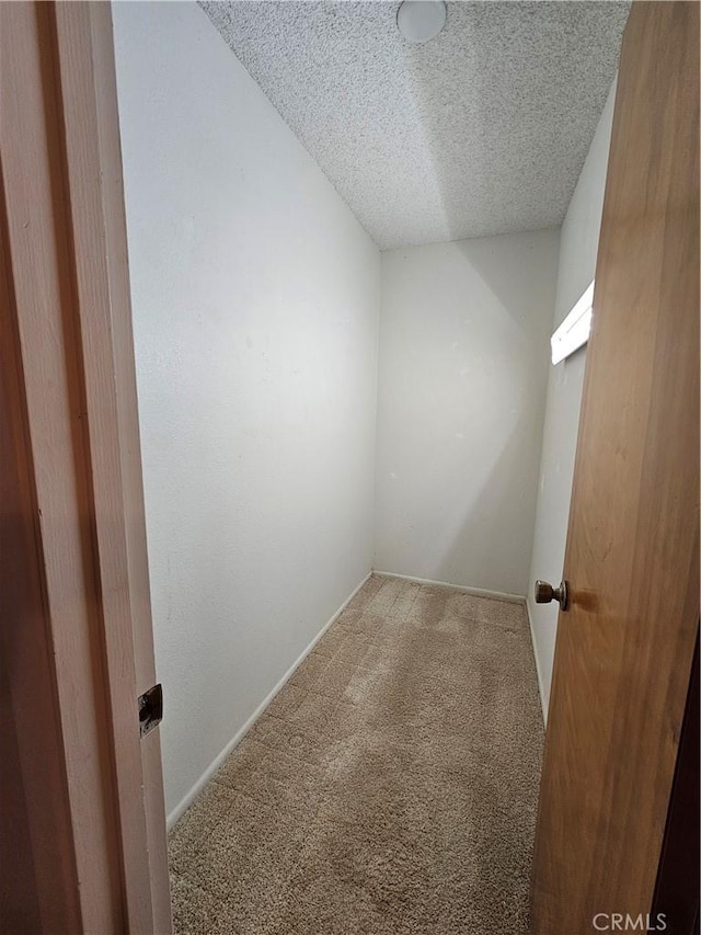 carpeted empty room with baseboards and a textured ceiling