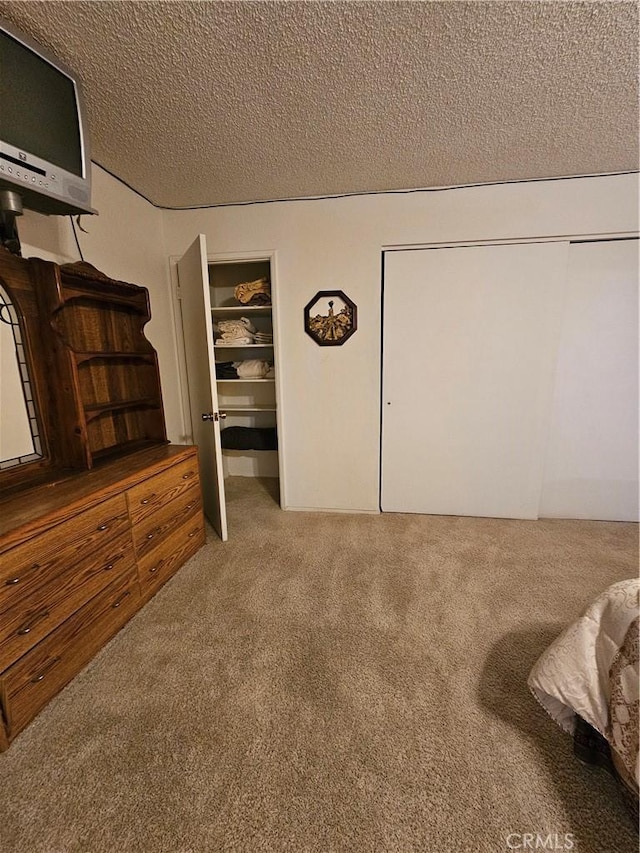 carpeted bedroom featuring two closets and a textured ceiling