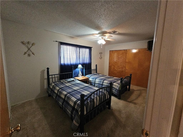 carpeted bedroom with visible vents, a textured ceiling, and a ceiling fan