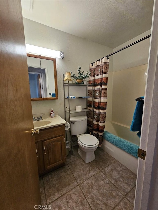 full bathroom featuring tile patterned flooring, toilet, shower / tub combo with curtain, vanity, and a textured ceiling