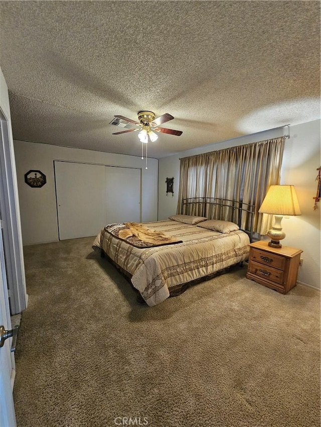 carpeted bedroom with a closet, a textured ceiling, and a ceiling fan