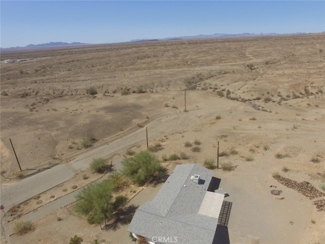 birds eye view of property featuring a mountain view, a rural view, and view of desert