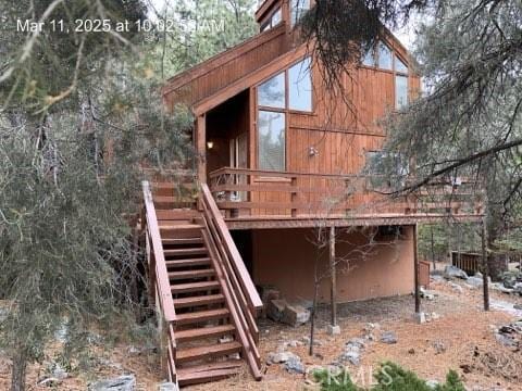 rear view of house with stairs and a wooden deck