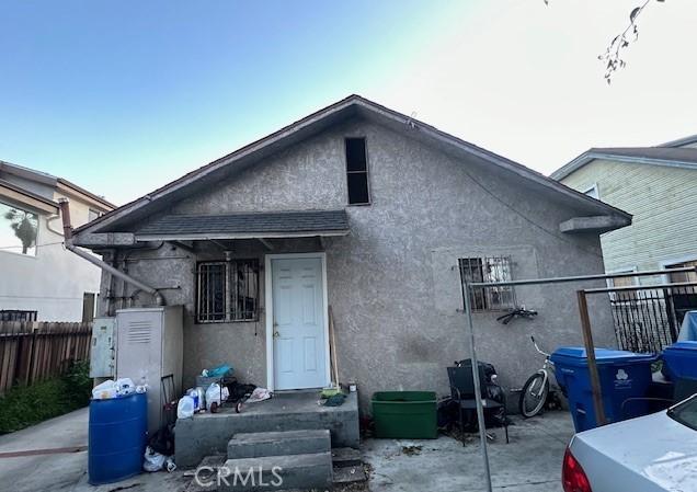 rear view of property with fence and stucco siding