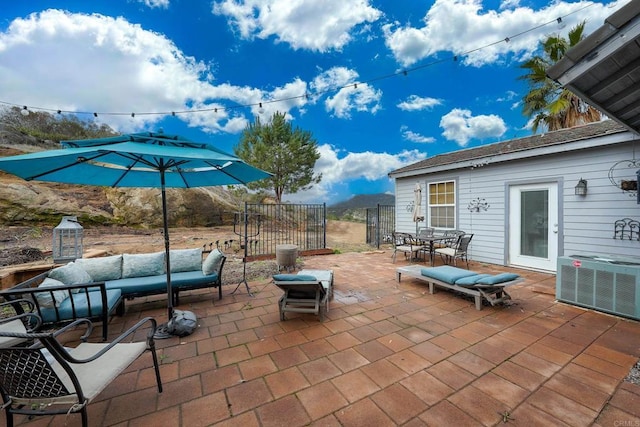 view of patio with outdoor dining space, an outdoor living space, central AC, and fence