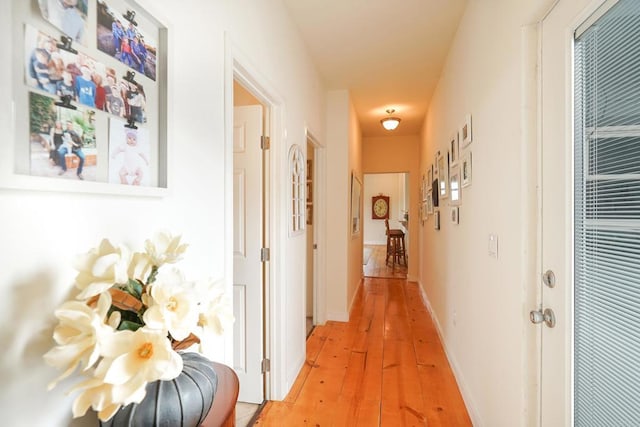 hallway with baseboards and light wood finished floors