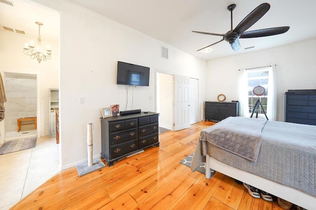 bedroom featuring visible vents, ceiling fan with notable chandelier, light wood-type flooring, and baseboards