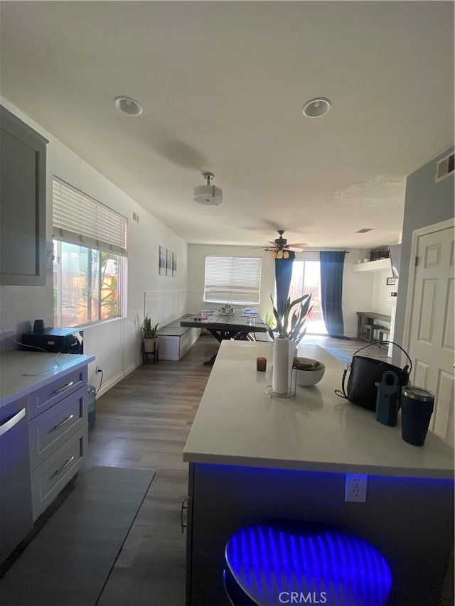 kitchen featuring visible vents, dark wood finished floors, ceiling fan, light countertops, and dishwasher